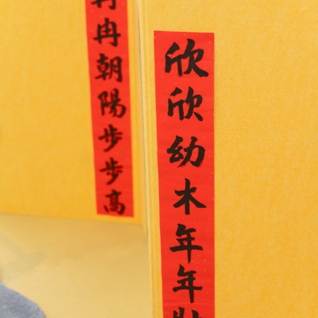 Red banners with black Chinese calligraphy characters are displayed on a yellow background.